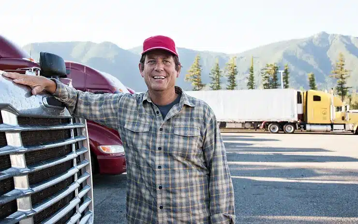 Truck driver standing in front of his truck